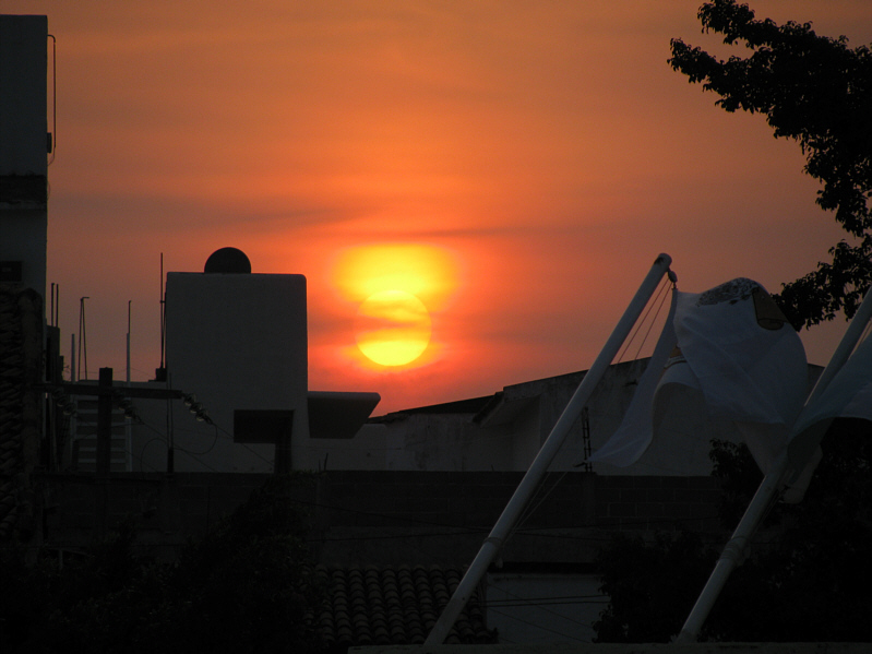 Unfortunately, the sun is setting behind another resort rather than into the ocean.