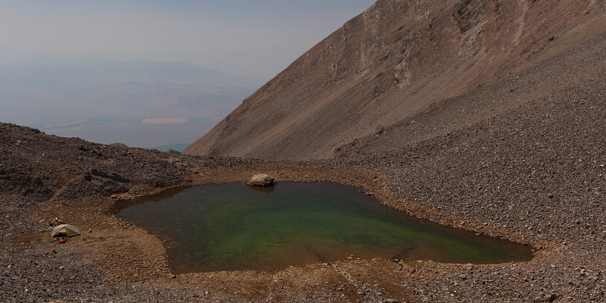That green colour is from algae. Get your water from the spring further down or bring a filtration device.